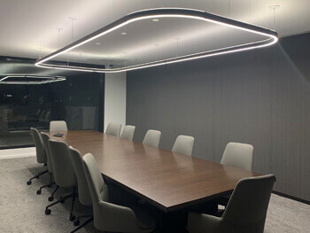 View of a corporate board room that includes a custom light fixture